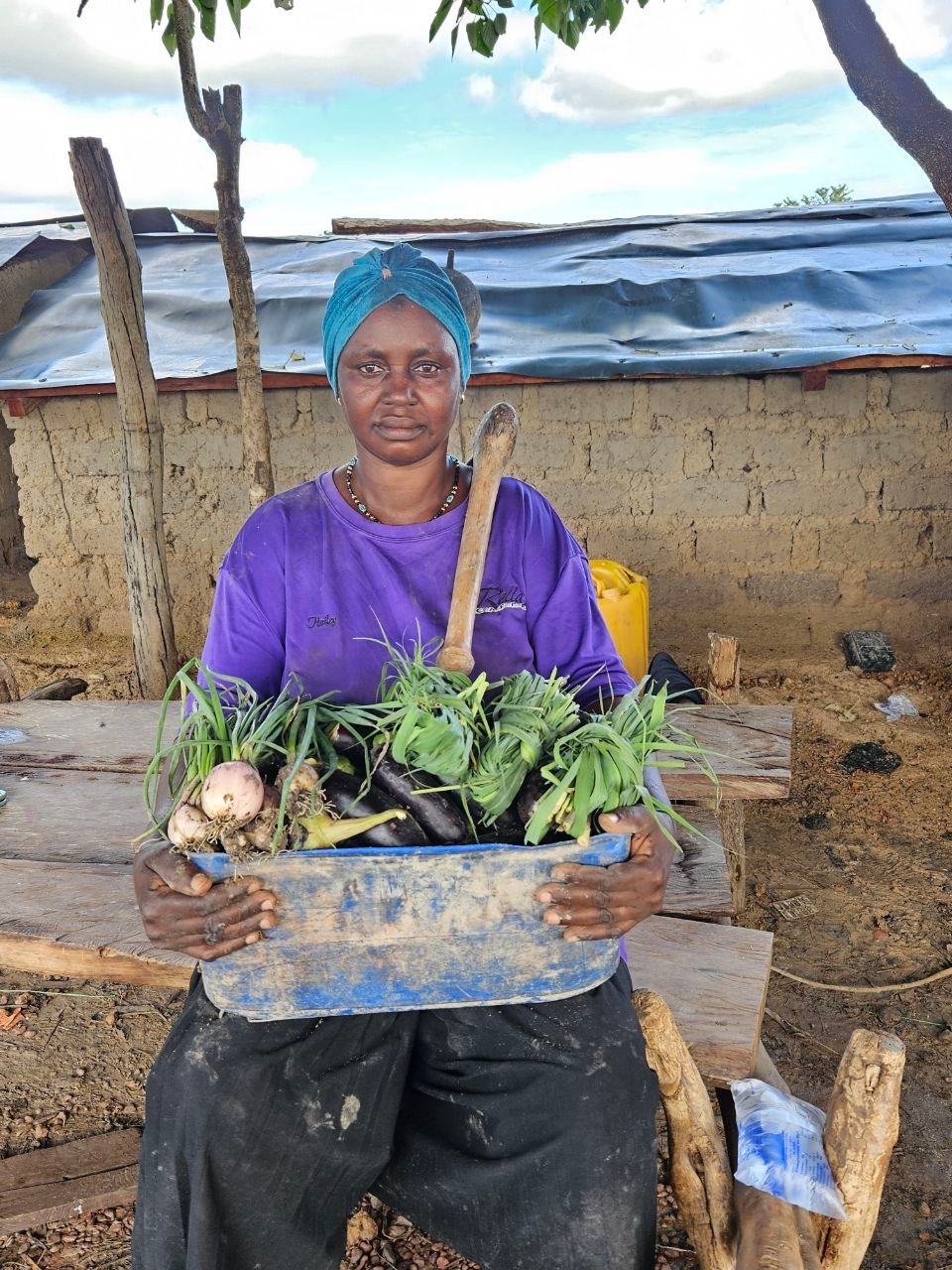 Waraba dans son champ avec un panier de produit agricole en main - @Afiwa