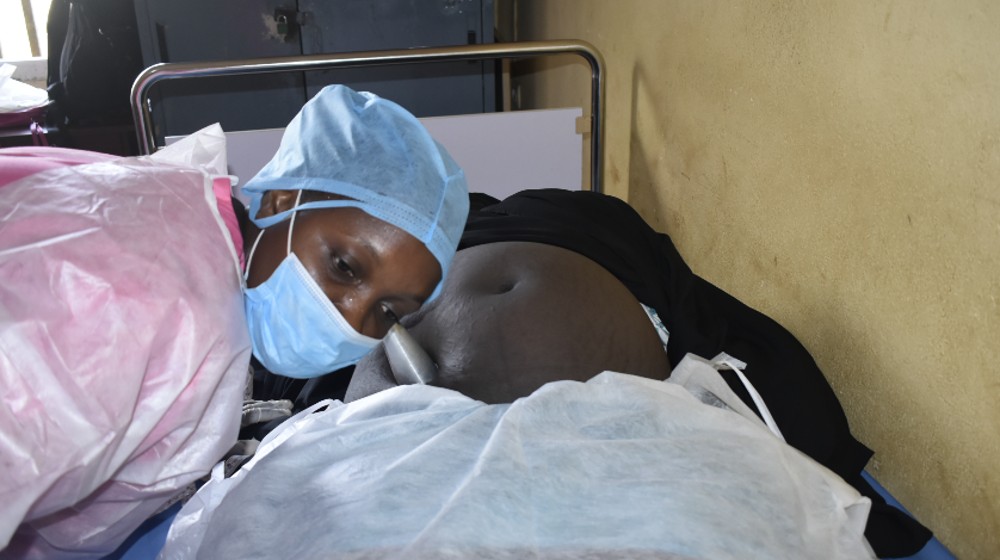 Sage femme du centre de santé Flamboya de Conakry, écoutant les mouvement du bébé 
