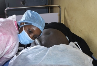 Sage femme du centre de santé Flamboya de Conakry, écoutant les mouvement du bébé 
