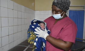 Sage femme donnant les premiers soins au nouveau né au centre de santé de Ratoma - Conakry