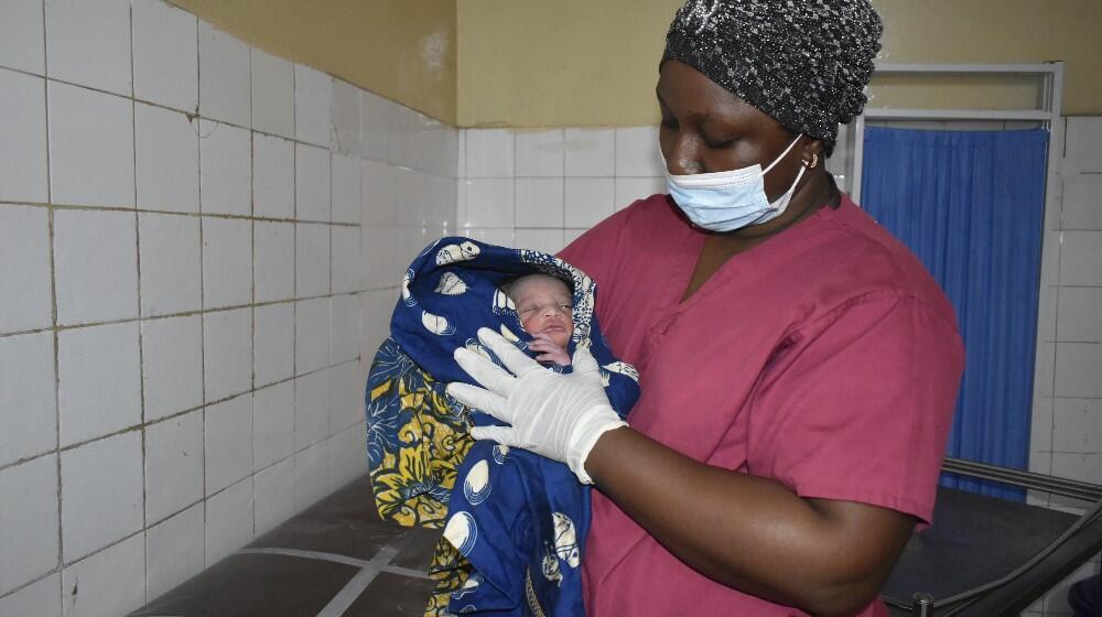 Sage femme donnant les premiers soins au nouveau né au centre de santé de Ratoma - Conakry